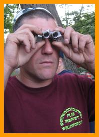 Man looking through miniature binoculars