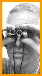 Man looking through miniature binoculars