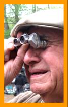 Man looking through miniature binoculars