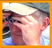 Man watching demolition derby through binoculars