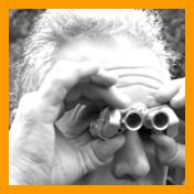 man with wild hair looking through binoculars