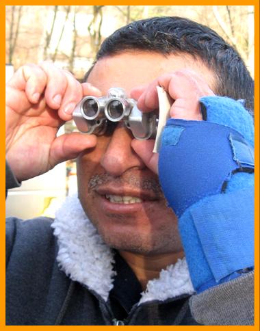 Hispanic man looking through miniature binoculars.
Mann schaut durch ein miniatur fernglas. 
Homme regardant a travers de jumelles miniature.
Hombre observando con binoculares prismaticos en miniatura.
Man observerar med miniatur kikare.
L'uomo osserva con il binocoloin miniatura 