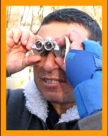 Disabled man using miniature binoculars.