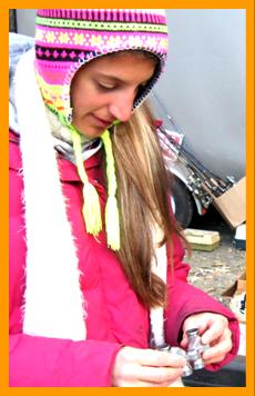 Woman Examining Miniature Binoculars in the cold