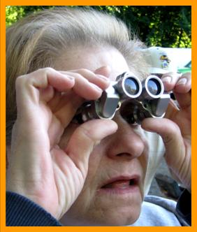 Old Woman looking through miniature  Binoculars.
Woman using biinoculars.
Woman with binoculars.
Femme utilisant de jumelles.
Frau schaut durch ein miniatur fernglas.
Femme regardant a travers de jumelles miniature.
Mujer mirando a traves de binoculares en miniatura prismatoicos.
Donna che guarda attaraverso il binocolo in miniatura.
Donna che usa il binocolo.
Vrouw met verrekijker.
Kvinne som bruker kikkert.
Kobieta za pomoca lotnetki.
Muz pouzvajici dalekohled.
Kvinde de burger en kikkert.
No hasznal tavcsovet.
Nainen kayttaa kiikareita.
Mulher usando binoculos.
Sieviete kas izmanto binokli.
Moteris bessinaodojanti ziuronais. 
6x15 binoculars.
7x18 binoculars.
