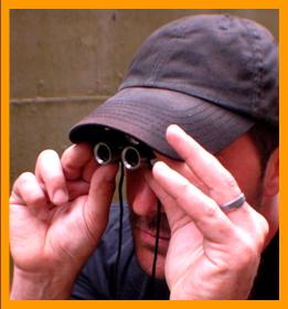 Man Peering through Miniature Binoculars.
Man looking through binoculars.
Man using binoculars.
Homme observant avec des jumelles miniature.
Man beobachtet mit einem miniatur fernglas.
Homme observant avec des jumelles miniature.
Man Observerar med miniatur kikare.
L'uomo osserva col il binocolo in miniatura. 
Man met verrekijker.
Man med kikkert.
Mezczyzna z lornettka.
Muz s dalekohled.
Mand med likkert.
Tavcsovel rendelkezo ferfi.
Mies jolla on kiikarit.
Homem com binoculos.
Virietis ar binokli.
Vyras so ziuronu.
6x15 binoculars.